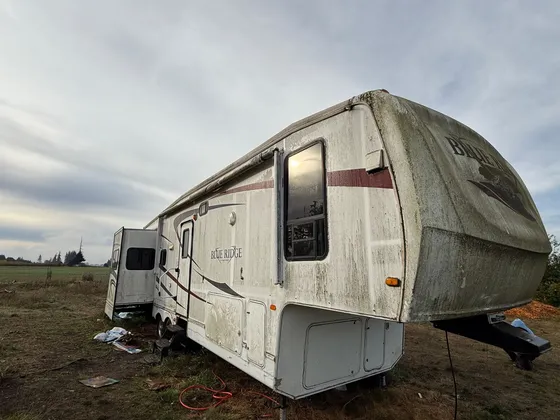 Blue Ridge fifth wheel sitting in a field with green mildew streaks across the front cap and walls