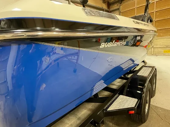 Close view of the blue hull side of a Centurion Avalanche C4 boat on its black trailer