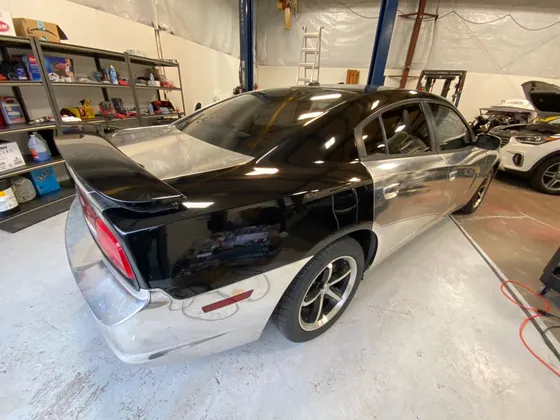 Dodge Charger with chrome silver film removed from the rear half, showing black paint underneath