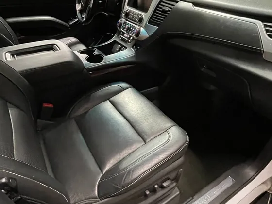 Black leather front passenger seat and dash of a GMC SUV seen through the open door in the shop