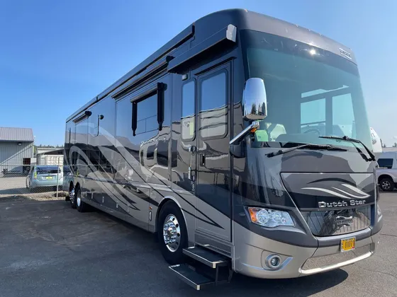 Gray and tan Dutch Star diesel motorhome parked in the lot, front driver side