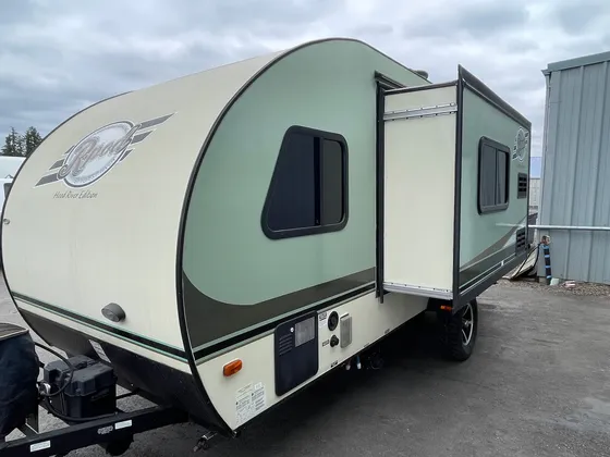 Green and cream R-Pod travel trailer with the slide-out extended, parked outside