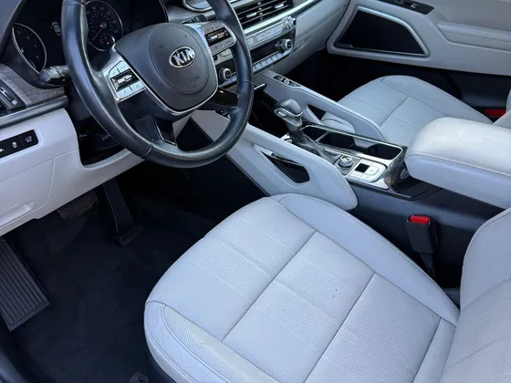 Front interior of a Kia Telluride with light gray leather seats and a black steering wheel