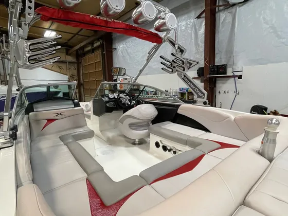 Gray and red vinyl seating and helm inside a MasterCraft ski boat under a metal wake tower