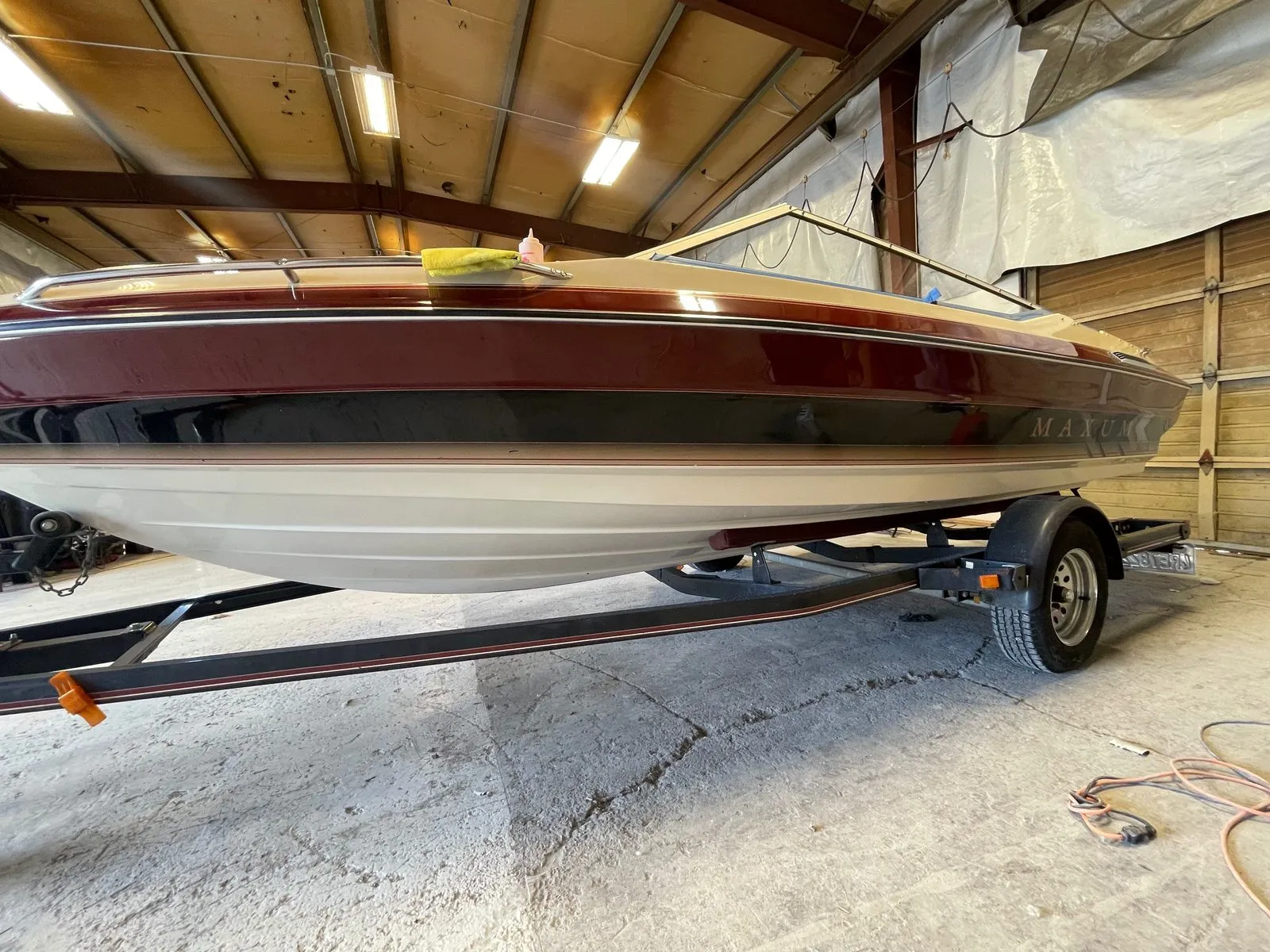 The same Maxum runabout on its trailer in the shop with the hull polished