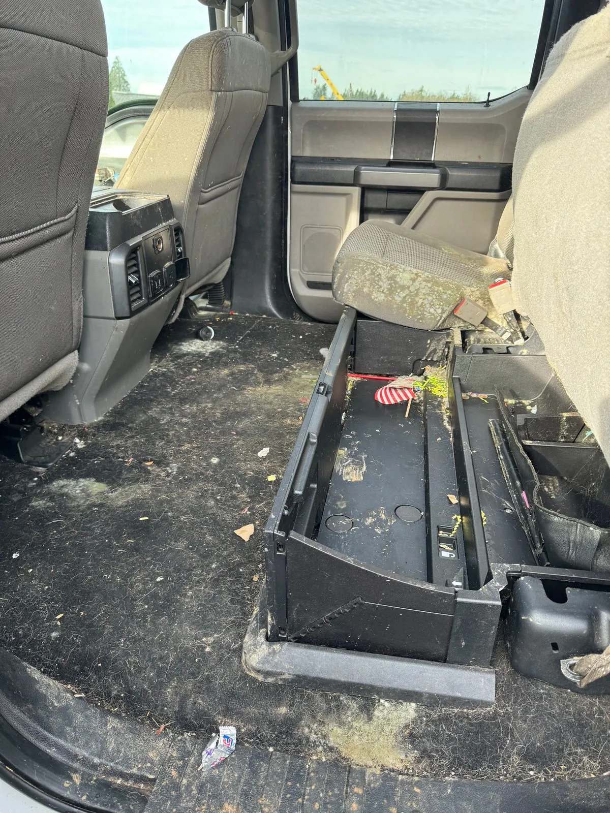 Crew cab pickup back seat area with a dirty carpet, mold spots and the seat folded up