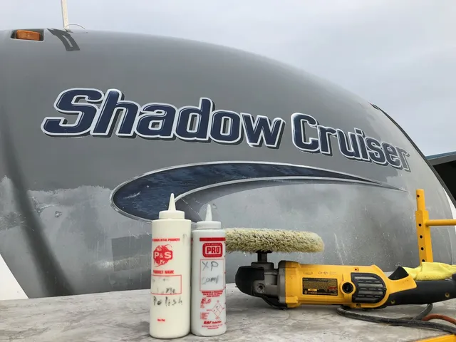 Polisher and two bottles of compound resting on a Shadow Cruiser trailer front cap with oxidized patches